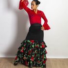 Falda Carmen de Paralola en color negro con volantes de crespon fondo negro con estampado de flores rojas y hojas verdes.